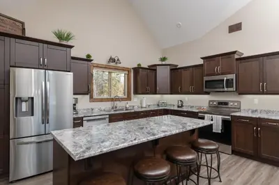 a kitchen with stainless steel appliances and wooden cabinets at Summit View in Valemount