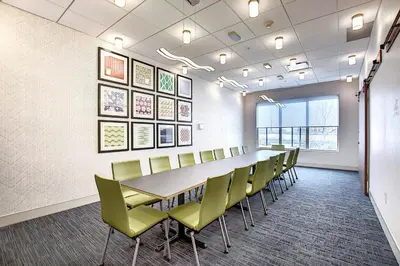 a conference room with a long table and chairs at Holiday Inn Express & Suites - Calgary Airport Trail NE by IHG in Calgary