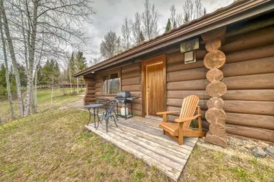 a cabin with a wooden deck with a table and chairs at Terracana Ranch Resort in Tete Jaune Cache