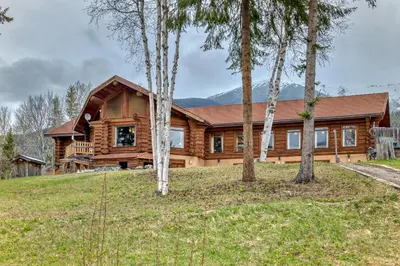 a log home with trees in front of it at Terracana Ranch Resort in Tete Jaune Cache