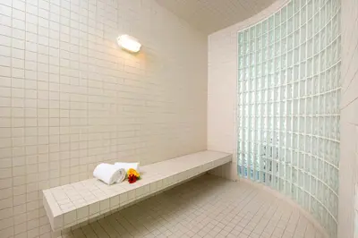 a bathroom with a bench with towels and a window at Gold Eagle Lodge in North Battleford