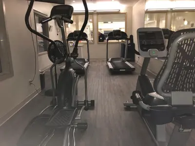 a gym with several treadmills and exercise bikes at Gold Eagle Lodge in North Battleford