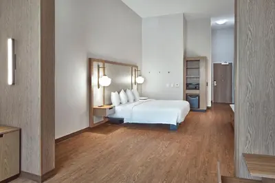 a hotel room with a white bed and a bathroom at Fairfield Inn & Suites by Marriott Penticton in Penticton