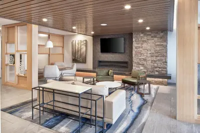 a living room with a couch and chairs and a tv at Fairfield Inn & Suites by Marriott Penticton in Penticton