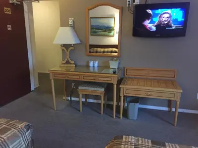a hotel room with a desk and a mirror at Hotel Deoro in Lillooet