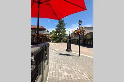 a red umbrella sitting on a sidewalk next to a street at Mountain Edge Ski-in Ski-out Condo in Kimberley