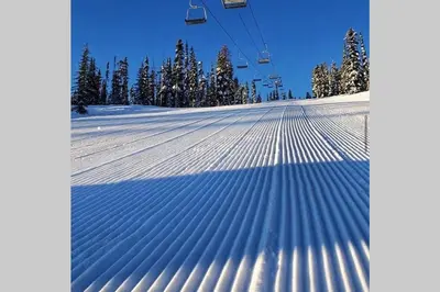a shadow of a ski lift on a snow covered slope at Mountain Edge Ski-in Ski-out Condo in Kimberley