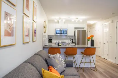 a living room with a couch and a kitchen at GlobalStay Cranbrook Townhome Suites in Calgary
