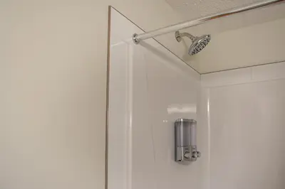 a shower in a bathroom with a glass door at GlobalStay Cranbrook Townhome Suites in Calgary