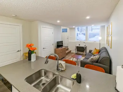 a kitchen with a sink and a living room at GlobalStay Cranbrook Townhome Suites in Calgary