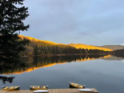 two boats sitting on a dock on a lake at Lac Des Roches Resort in Bridge Lake
