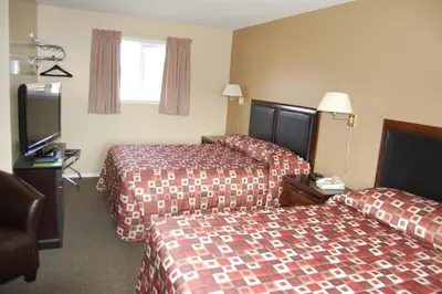 a hotel room with two beds and a flat screen tv at Monte Carlo Motel in Barrière