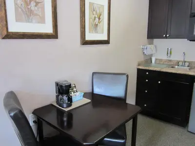 a kitchen with a table and chairs with a coffee maker on it at Monte Carlo Motel in Barrière