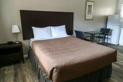 a hotel room with a large bed and a table at Richter Pass Beach Resort in Osoyoos