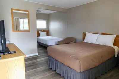 a hotel room with two beds and a television at Richter Pass Beach Resort in Osoyoos
