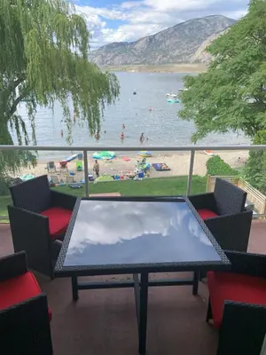 a balcony with a table and chairs and a view of a beach at Richter Pass Beach Resort in Osoyoos