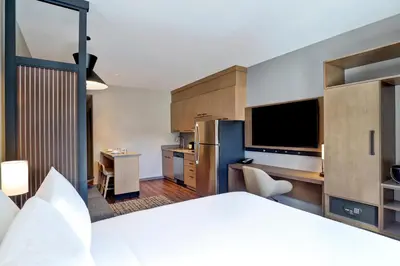 a hotel room with a bed and a kitchen at Hyatt Place Prince George in Prince George