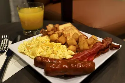 a plate of breakfast food with sausage eggs potatoes and toast at Hyatt Place Prince George in Prince George