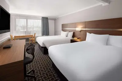 a hotel room with two beds and a desk at Baymont by Wyndham Edson in Edson
