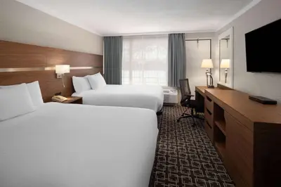 a hotel room with two beds and a television at Baymont by Wyndham Edson in Edson