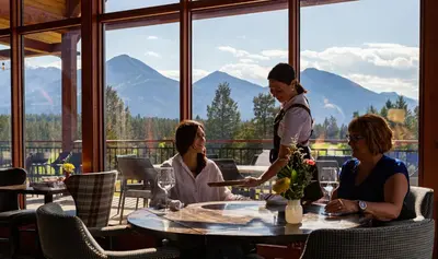 a group of people sitting at a table in a restaurant at Headwaters Lodge at Eagle Ranch Resort in Invermere