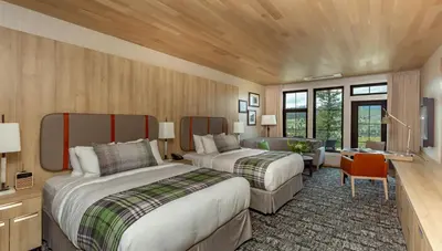 a hotel room with two beds and a desk at Headwaters Lodge at Eagle Ranch Resort in Invermere