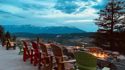 a row of chairs sitting on a deck with a view at Headwaters Lodge at Eagle Ranch Resort in Invermere