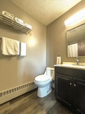 a bathroom with a white toilet and a sink at 7 Day's Hotel in Lamont