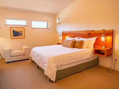 a bedroom with a large bed and a chair at The Moorage in Ucluelet