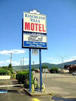 a sign for a motel in a parking lot at Ranchland Villa Motel in Merritt