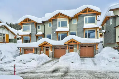 a house covered in snow with snow covered roofs at Echo Landing#02 By Bear Country in Sun Peaks