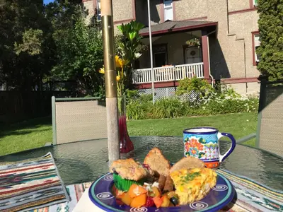 a plate of food on a table with a coffee cup at Stirling House in Kelowna