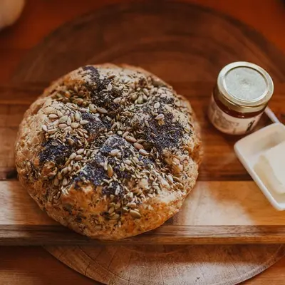 a seeded bagel sitting on a wooden cutting board at Ambleside Lodge Bed & Breakfast in Canmore