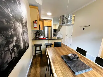 a kitchen and dining room with a wooden table and chairs at Renovated Chalet at Mystic Springs, Mountain Views, Pets Welcome! in Canmore