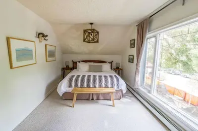 a bedroom with a bed and a large window at North House - Banff Mountain Home- The Real Rockies Experience in Banff