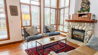 a living room with a fireplace and a couch and chairs at Woodhaven #11 by Bear Country in Sun Peaks