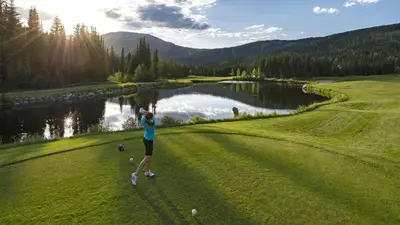 a woman is playing golf on a golf course at Echo Landing #12 by Bear Country in Sun Peaks