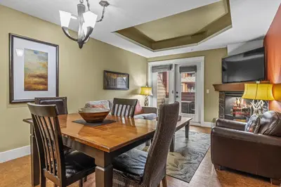 a dining room with a table and a fireplace at Sophisticated MTN 2 Bedroom Pool Hot Tub managed by Little Sister Getaways in Canmore