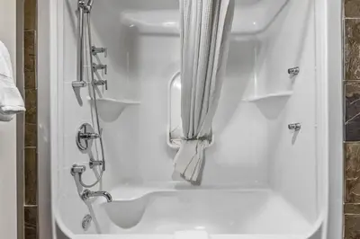 a bathroom with a shower with a shower curtain at Sophisticated MTN 2 Bedroom Pool Hot Tub managed by Little Sister Getaways in Canmore