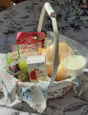 a basket filled with bread and fruit on a table at Sea Birds Cottage in Victoria