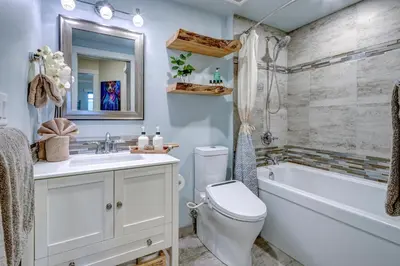 a bathroom with a tub and a toilet and a sink at Sunpath Retreat- Convenience Meets Comfort & Style in Whistler