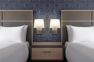 two beds in a hotel room with two lamps between them at Best Western Plus Prince George in Prince George