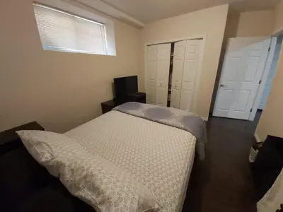 a bedroom with a bed and two white doors at Parson Creek Retreat in Fort McMurray