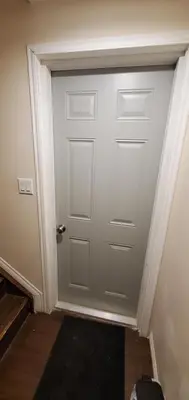 a white door in a room with a black rug at Parson Creek Retreat in Fort McMurray