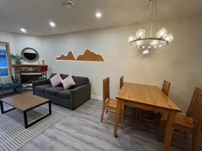 a living room with a table and a couch at Banff Woods lodge in Canmore