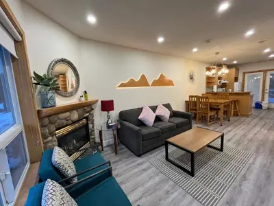 a living room with a couch and a fireplace at Banff Woods lodge in Canmore
