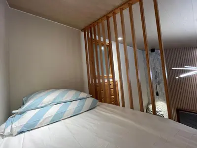 a bed with a blue and white pillow on it at Banff Woods lodge in Canmore