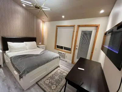 a bedroom with a bed and a table and a television at Banff Woods lodge in Canmore