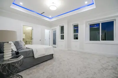 a large white bedroom with a bed and windows at Sun suite in Surrey