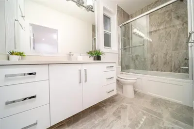 a white bathroom with a shower and a toilet at Sun suite in Surrey